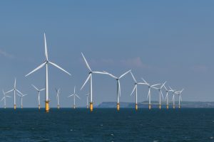 A photo of a row of wind turbines in an offshore wind farm