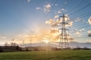 A stock photo of electricity pylons with a sunset in the background