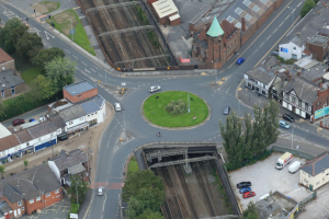 A photo of the bridge carrying a roundabout with a grassy middle over rail lines